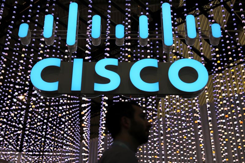 A man passes under a Cisco logo at the Mobile