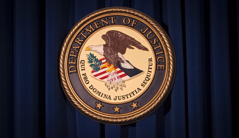 The DOJ logo is pictured on a wall after a