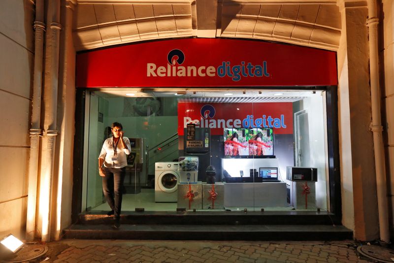 An employee leaves a store of Reliance Industries Ltd, controlled