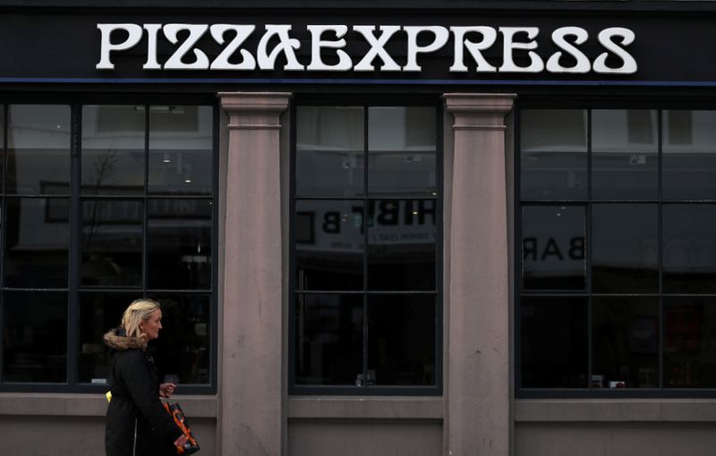 A woman walks past a Pizza Express restaurant in London
