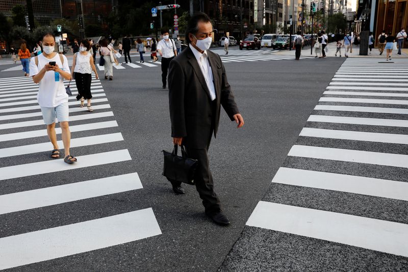 People wearing protective masks make their way at a business