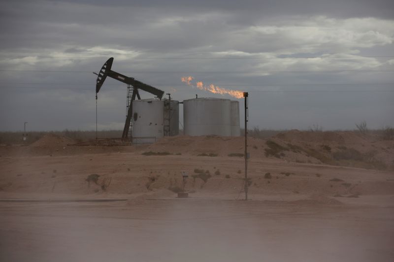 FILE PHOTO: Dust blows around a crude oil pump jack