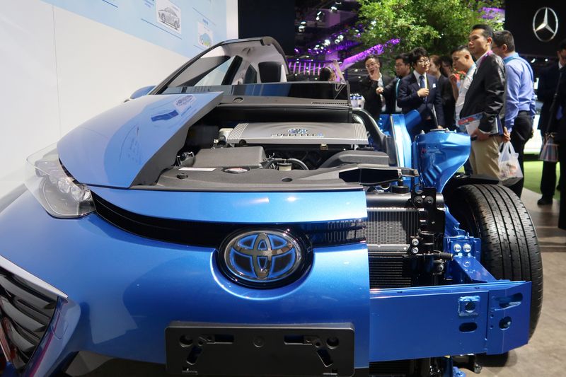 Visitors look at a display of Toyota’s Mirai hydrogen fuel-cell