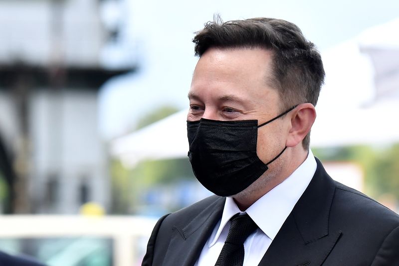 Elon Musk wears a protective mask as he arrives to