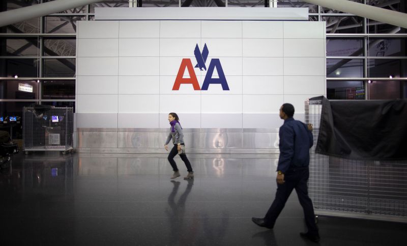 FILE PHOTO: People walk past an American Airlines logo at