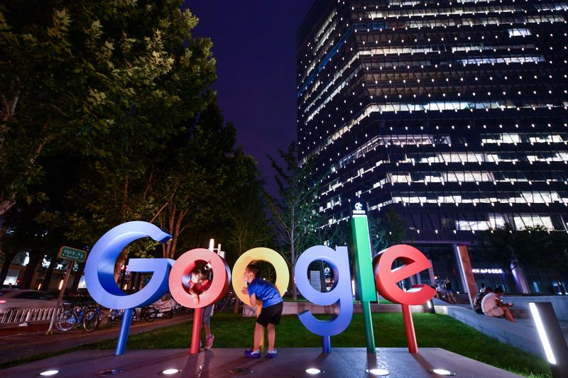 Children play around a sign of Alphabet Inc’s Google outside