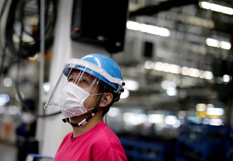 FILE PHOTO: FILE PHOTO: An employee wearing a protective face