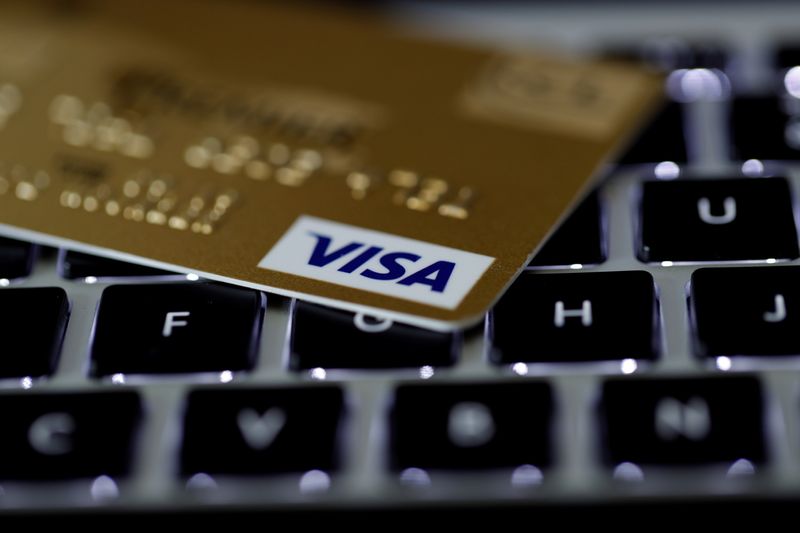 A Visa credit card is seen on a computer keyboard