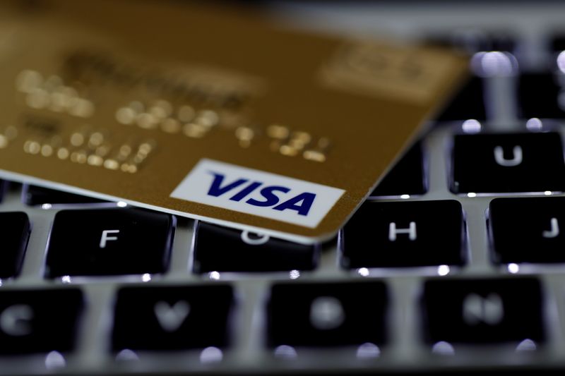 A Visa credit card is seen on a computer keyboard