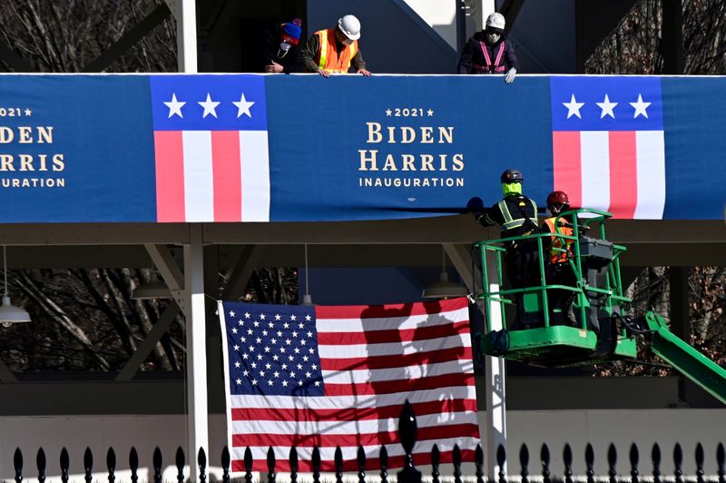 FILE PHOTO: Workers place Biden-Harris inauguration banners on the inaugural