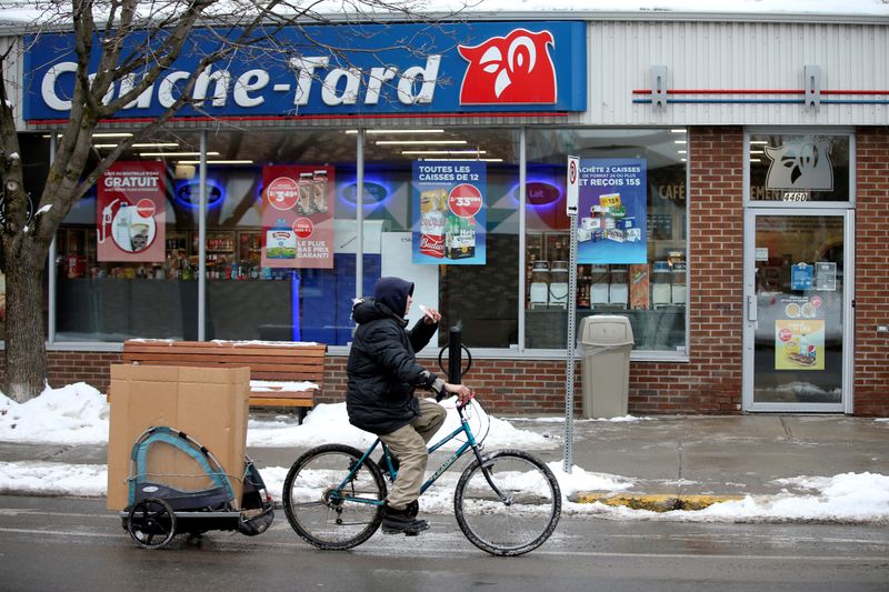 FILE PHOTO: FILE PHOTO: A man cycles past a Couche-Tard