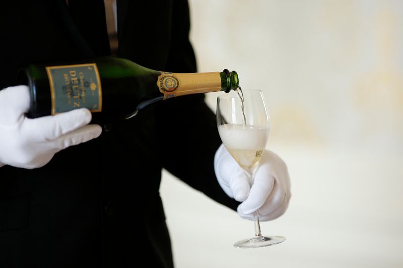 An employee serves a glass of Champagne during the traditional