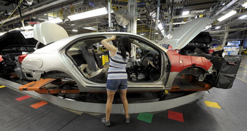 GM auto worker Martinez installs parts on a car at