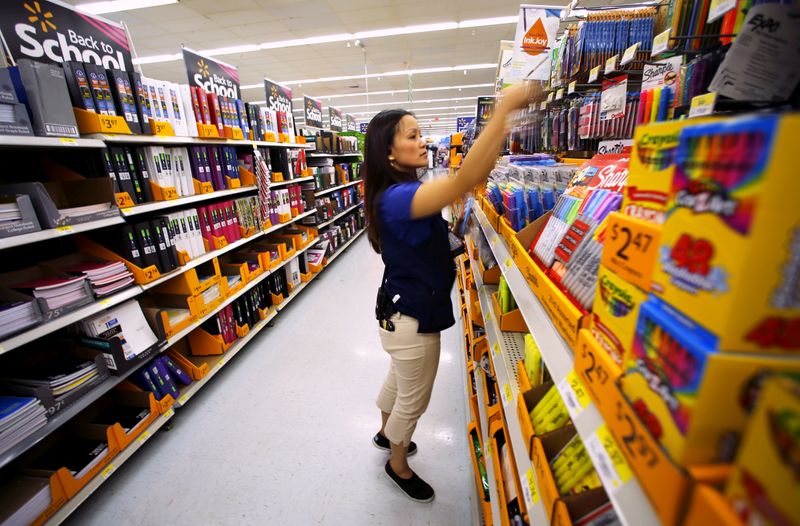 Walmart department manager Karren Gomes helps stock shelves with school
