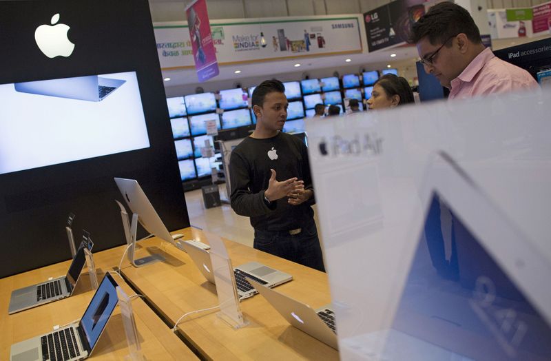 FILE PHOTO: An Apple salesperson speaks to customers at an