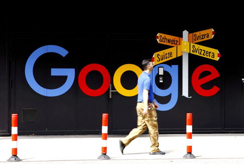 FILE PHOTO: A man walks past a logo of Google