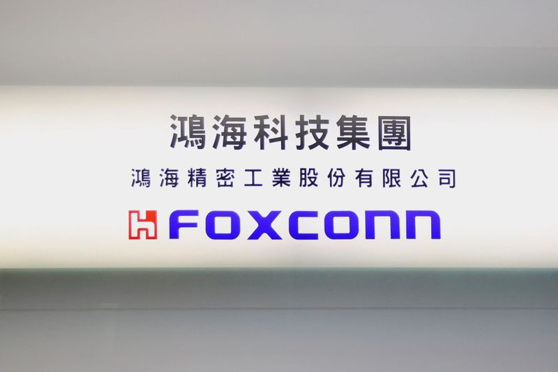 Sign of Foxconn is seen at a glass door inside