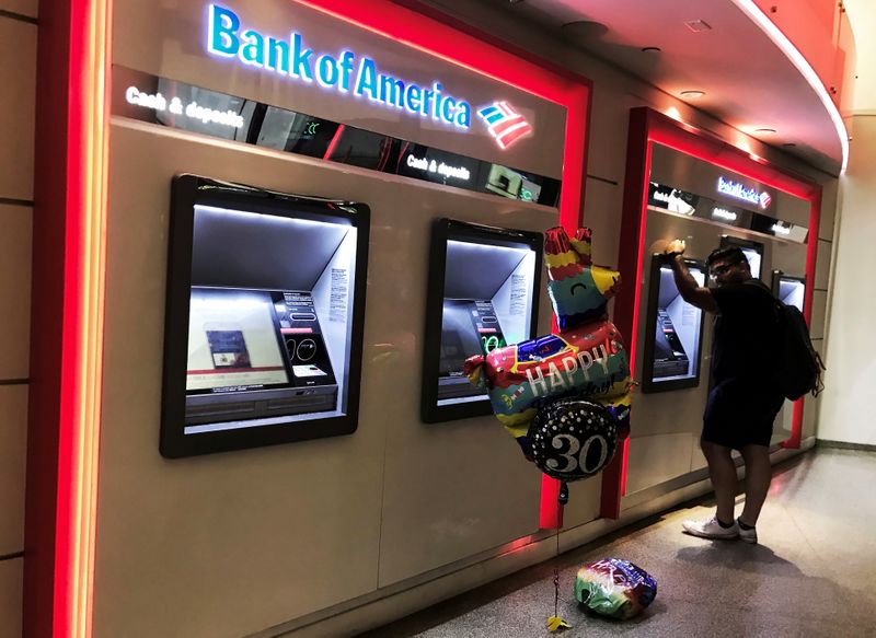 FILE PHOTO: A man uses an ATM machine next an