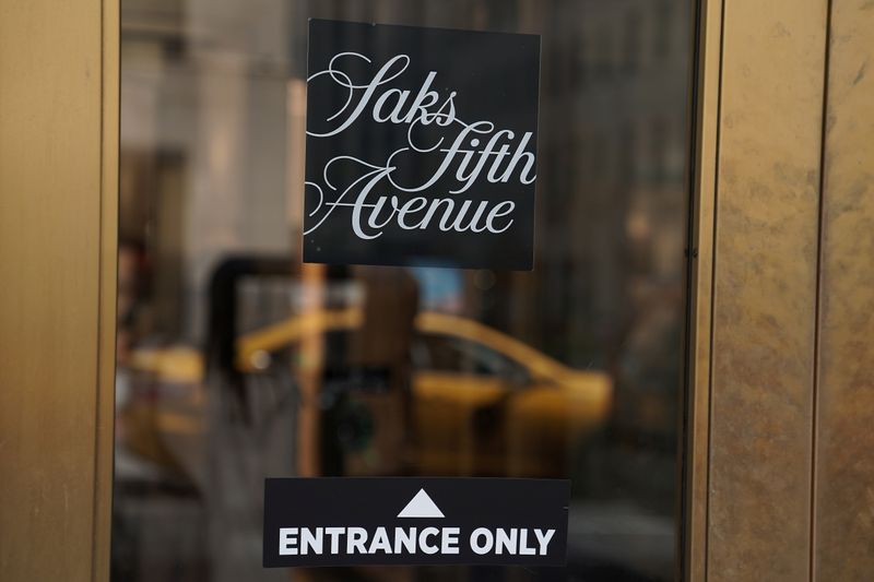 A taxi is reflected in a Saks Fifth Avenue window