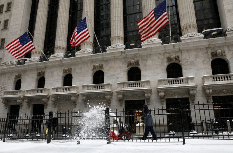 Workers clear snow from a sidewalk outside the NYSE during