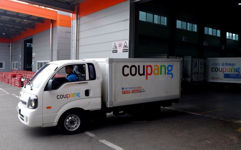 FILE PHOTO: Delivery trucks for e-commerce retailer Coupang leave a