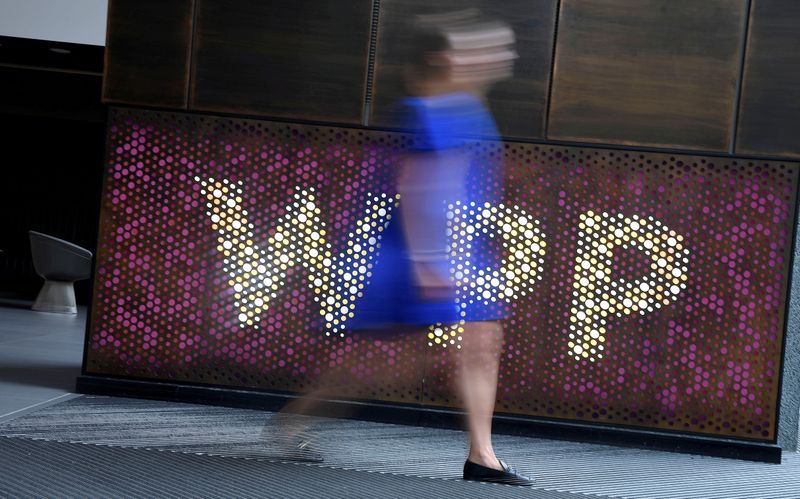 FILE PHOTO: A woman walks past signage for WPP at