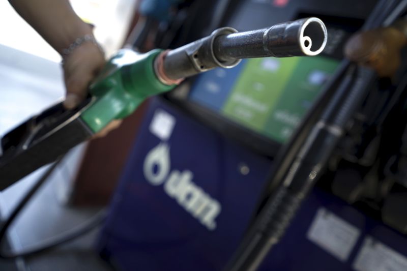 A worker grabs a nozzle at a PTT gas station