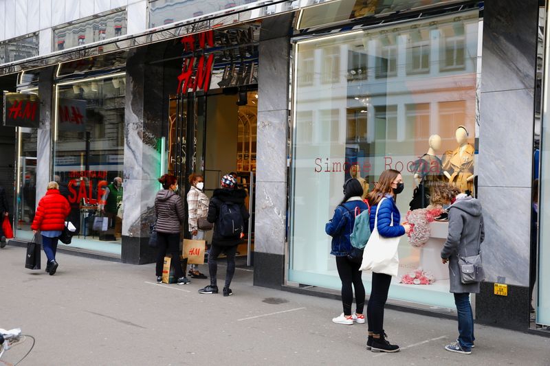 Clients wait in front of a re-opened H&M store after