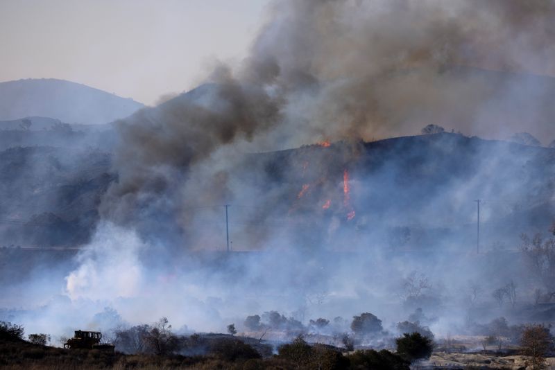 FILE PHOTO: A firefighting bulldozer battles the Bond Fire wildfire