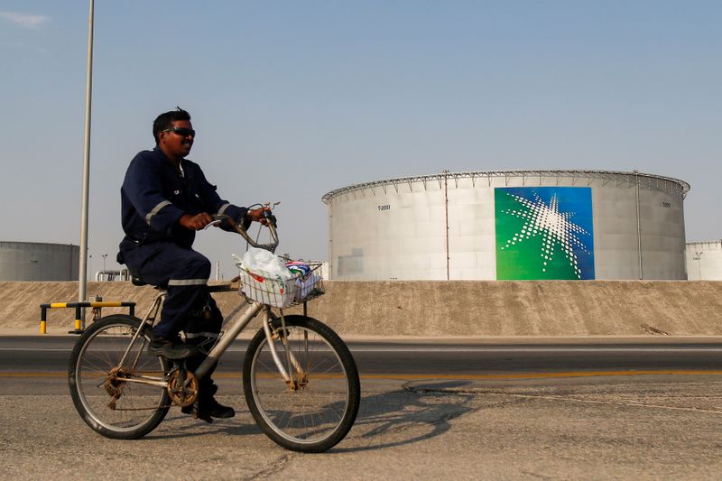 FILE PHOTO: An employee rides a bicycle next to oil