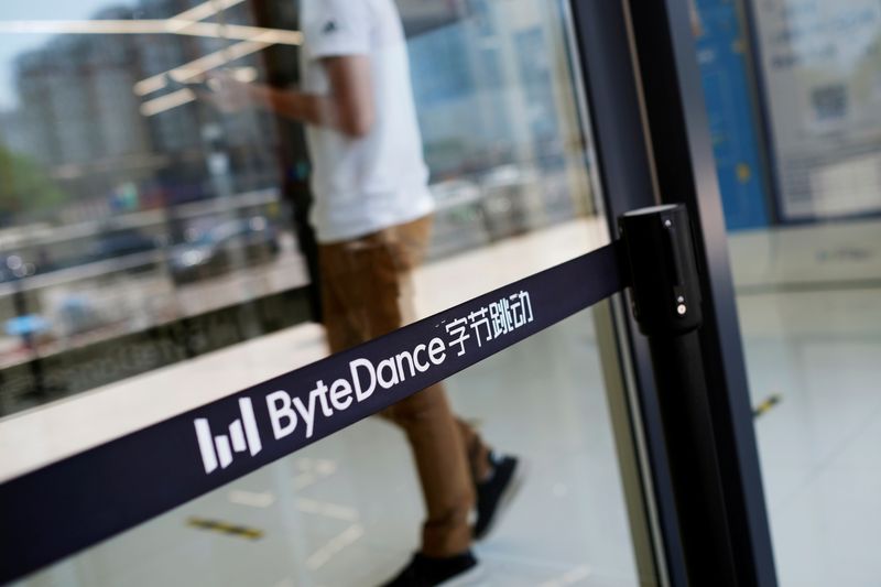 FILE PHOTO: Man walks by a logo of Bytedance, which