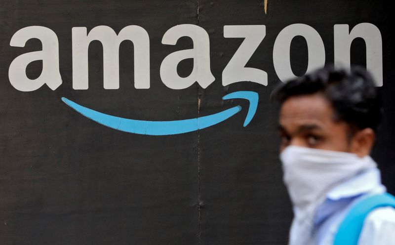 FILE PHOTO: A man walks past an Amazon logo outside