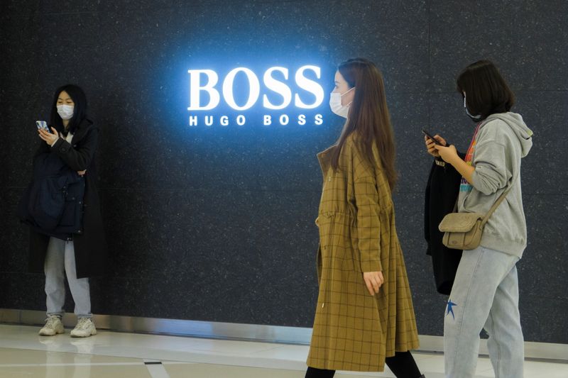People walk past a store of German fashion house Hugo