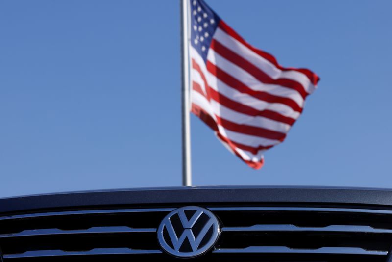 Volkswagen logo and American flag are shown at car dealershio