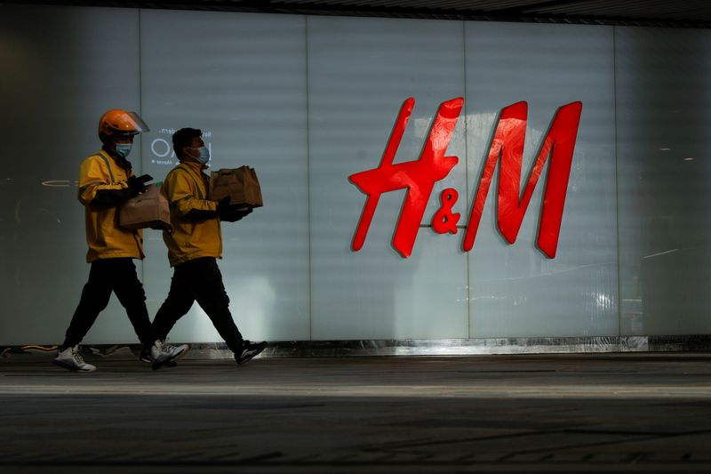 FILE PHOTO: People walk past an H&M store in a