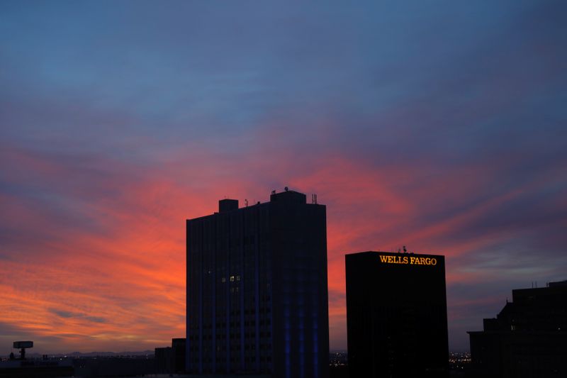 The sun rises behind a Wells Fargo building in El