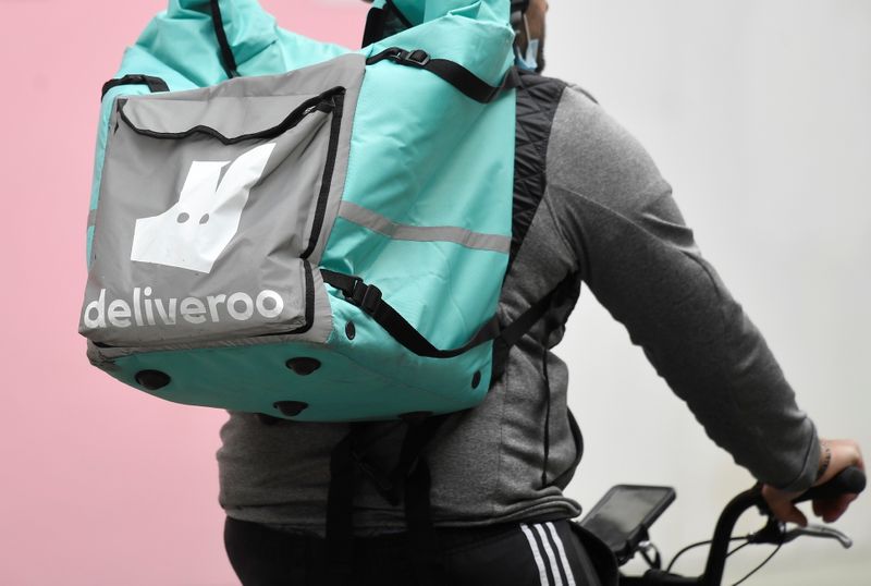 A Deliveroo delivery rider cycles in London