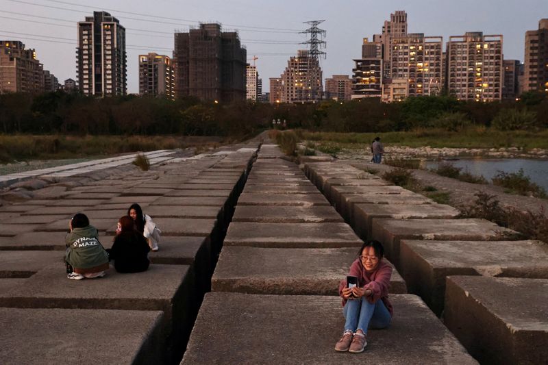 FILE PHOTO: People take photos on the drought-hit riverbed of
