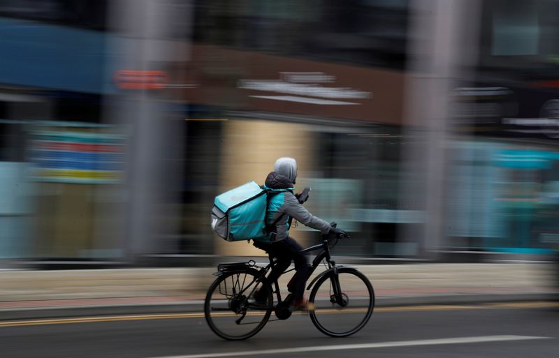 FILE PHOTO: A deliveroo delivery driver cycles through the centre