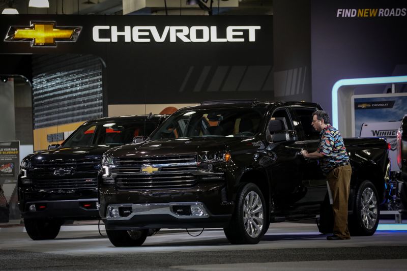 A man looks at a Chevrolet Silverado pickup truck during