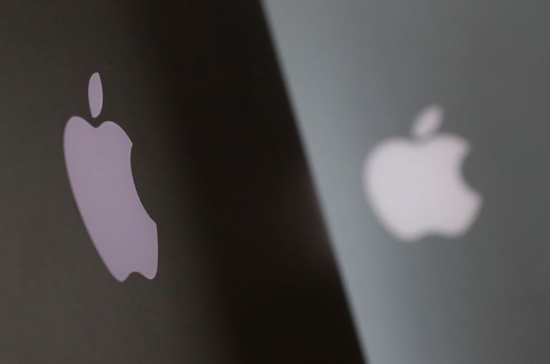 Apple company logos are seen as two MacBooks stand next