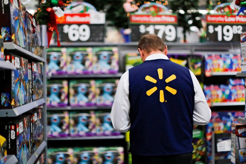 A Walmart worker organises products for Christmas season at a