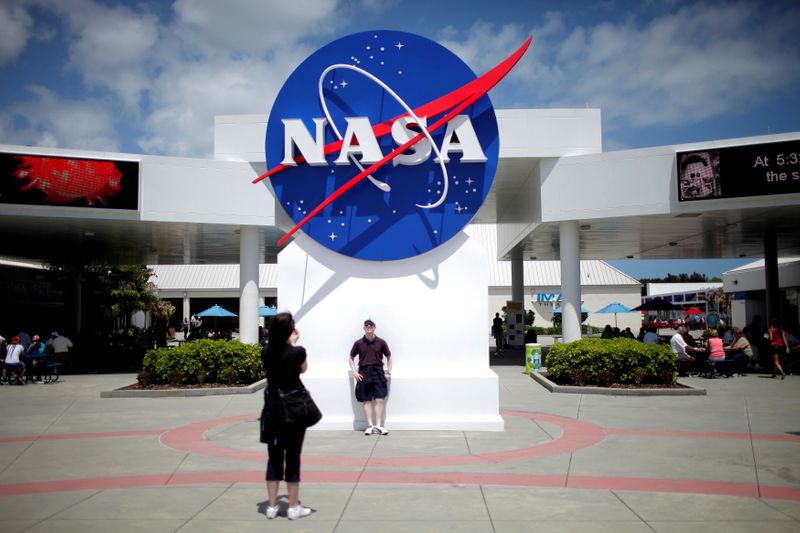 FILE PHOTO: Tourists take pictures of a NASA sign at