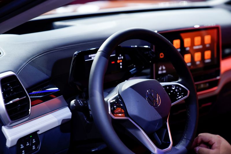 A Volkswagen logo is seen on a steering wheel as