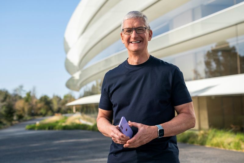 Apple CEO Tim Cook holds an iPhone 12 in a