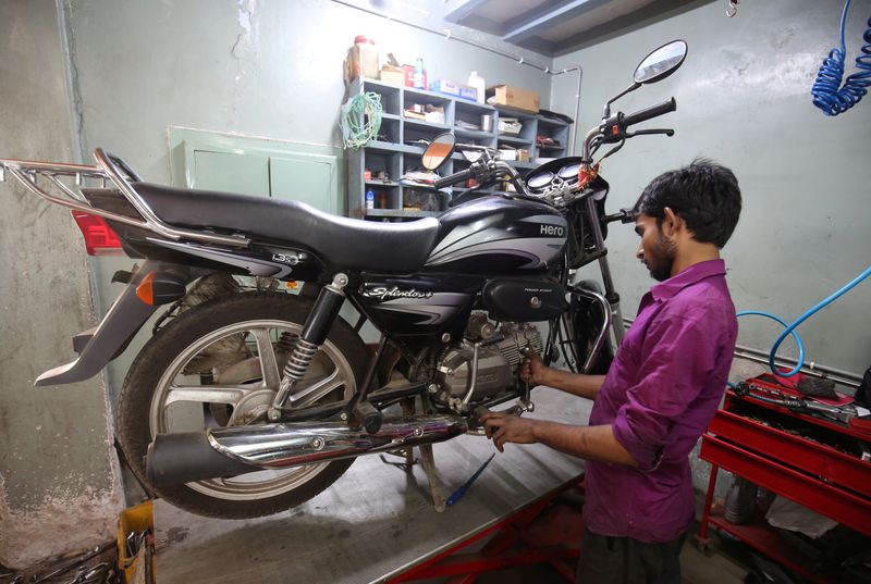 An employee works on a motorbike inside a Hero MotoCorp