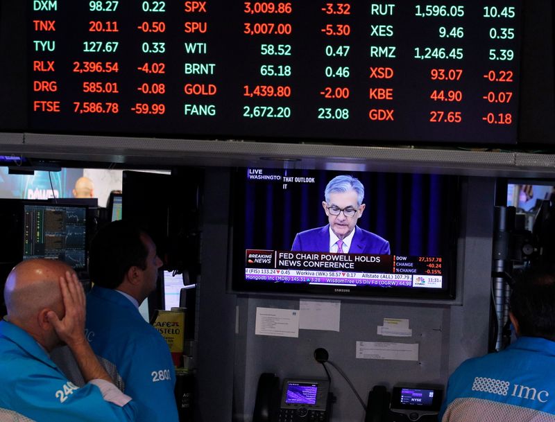 FILE PHOTO: Traders look on as a screen shows Federal