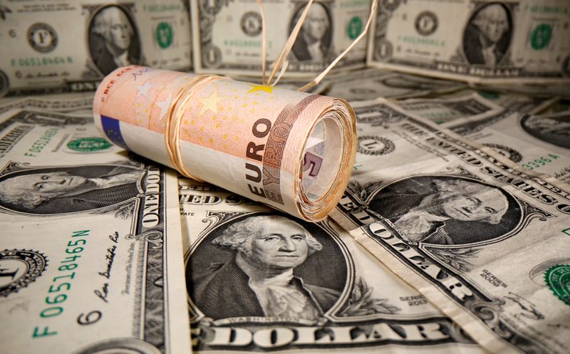 FILE PHOTO: Rolled Euro banknotes are placed on U.S. Dollar