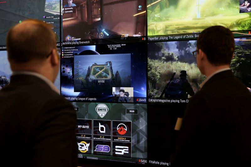 FILE PHOTO: Men look at a wall of real-time video