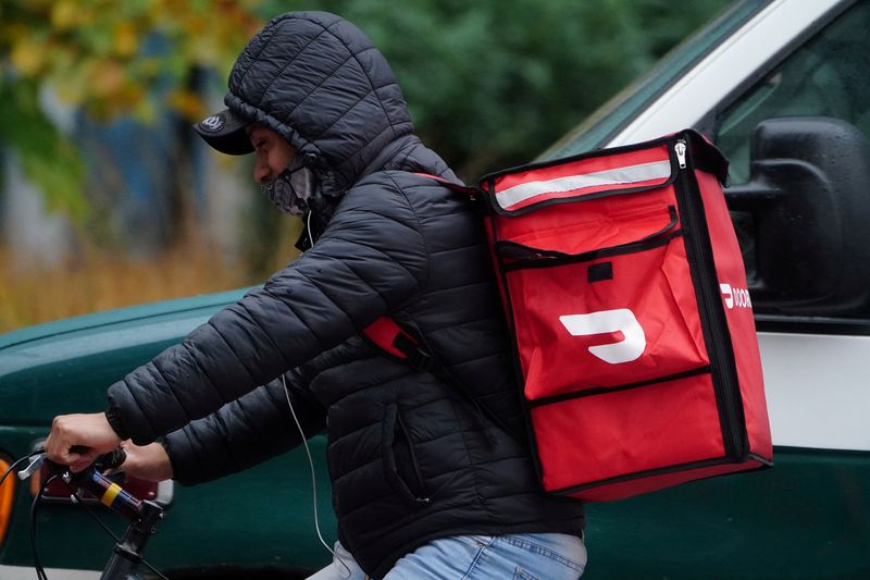 A delivery person for Doordash rides his bike in the